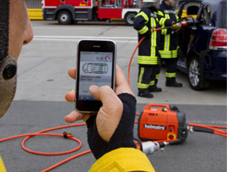 Ein Feuerwehrmann schaut sich per Smartphone das Rettungsdatenblatt eines Autos an. Bildquelle: Opel