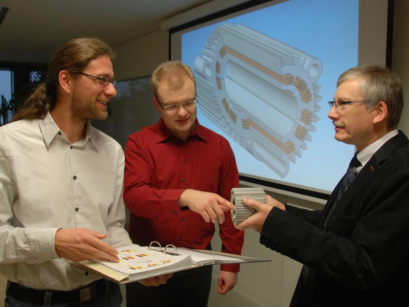 Mathias Lindner, Patrick Bräuer und Prof. Dr. Ralf Werner (v.l.) von der Professur Elektrische Energiewandlungssysteme und Antriebe der TU Chemnitz diskutieren, wie sich die Kennwerte bei einem Stator eines elektrischen Antriebsmotors voraussichtlich verbessern, der künftig mittels Siebdruck gefertigt werden soll. Foto: TU Chemnitz/Mario Steinebach