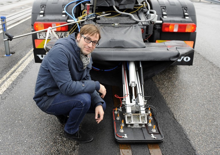 Das System erinnert ein wenig an die Straßenbahn, nur das hier der Strom in der Straße entlang fließt. Richard Sebestyen mit dem Stromkollektor am Heck des test-Trucks. Bild: Volvo Group