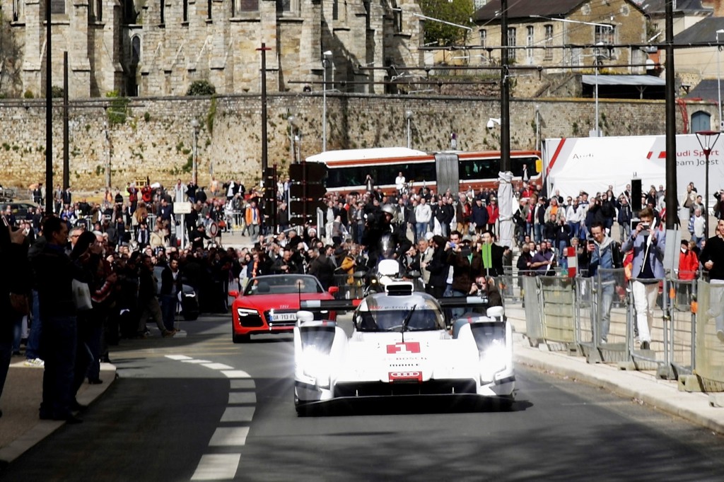 Audi ist mit einem spektakulaeren Auftritt in die WEC-Saison 2014 gestartet: Der neue Audi R18 e-tron quattro absolvierte seine ersten Kilometer in Le Mans nicht auf der legendaeren Rennstrecke in Westfrankreich, sondern im oeffentlichen Strassenverkehr.  Le Mans: R18 e-tron quattro Fahrt im öffentlichen Straßenverkehr. Bildquelle: Audi/dpp-AutoReporter